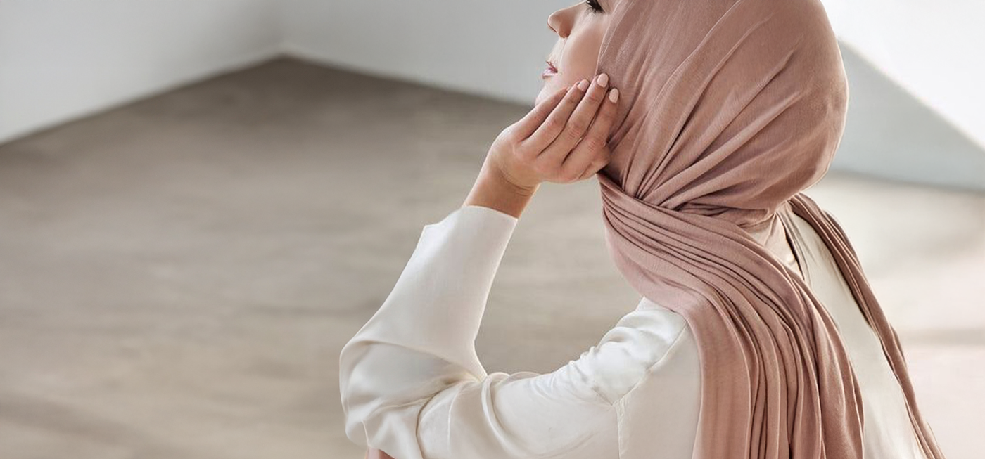 Woman wearing a beige hijab in a minimalistic room